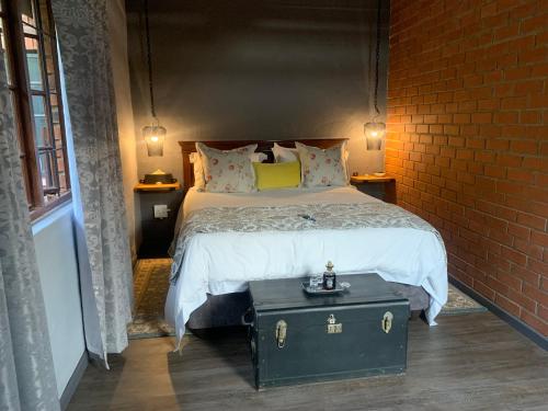 希尔顿Greenwood Lea Cottage - luxury, romantic cottage的一间卧室设有一张床和砖墙