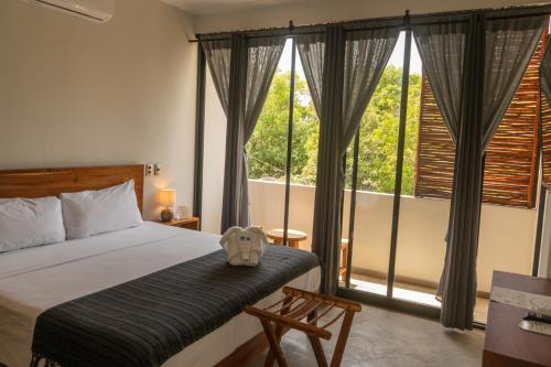 图卢姆Hotel Muyu Tulum的一间卧室设有一张床和一个大窗户