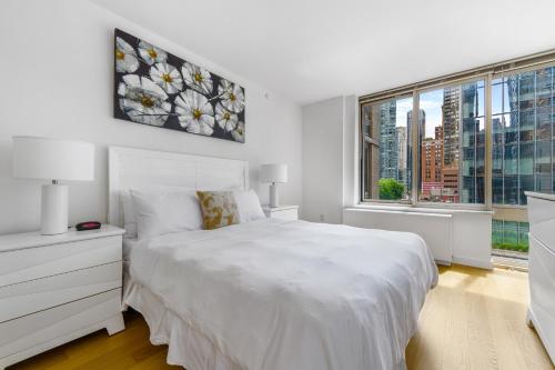 纽约Global Luxury Suites at The Marc的白色的卧室设有白色的床和窗户。