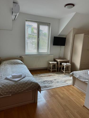 大特尔诺沃Apartment VEDA 2的一间卧室配有一张床、一张桌子和一个窗户。