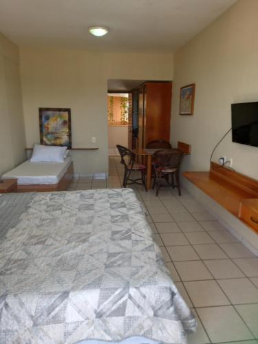 纳塔尔Maria Leuça Teixeira Duarte的一间卧室配有一张床、一台电视和一张桌子