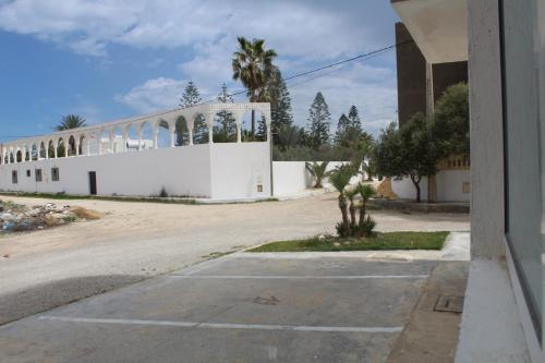 RejicheRelaxing Vacation Stay in Mahdia的一座白色的建筑,旁边种有棕榈树