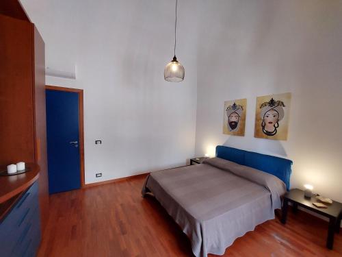 卡塔尼亚Terrazza San Camillo的卧室配有一张床,墙上挂有两张照片
