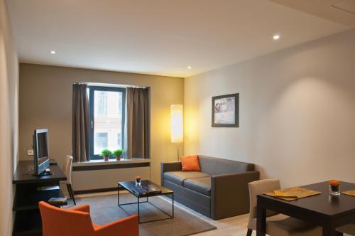 根特Castelnou Aparthotel的客厅配有沙发和桌子