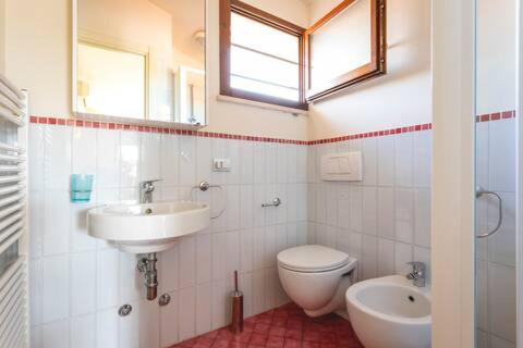 米兰马瑞提那Appartamento Perla Marina的一间带水槽、卫生间和镜子的浴室