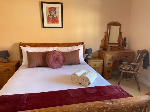 LincolnshireRasen Cottage的一间卧室配有一张带两条毛巾和镜子的床