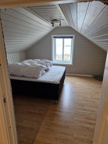 安德内斯Roligheten Lodge in Andenes的阁楼上的卧室设有一张床,设有窗户