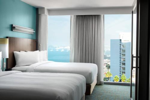 圣地亚哥万豪圣地亚哥市中心/海湾春季山丘套房酒店的配有大窗户的酒店客房内的两张床