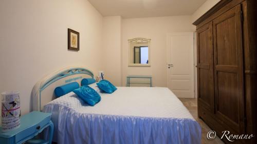 坎波罗索Villa Montefontane的一间卧室配有一张带蓝色枕头的床。