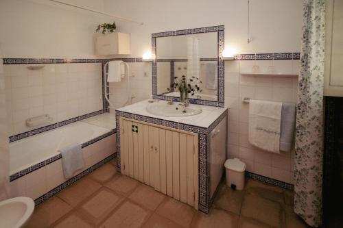 Cottage São Veríssimo的一间带水槽、浴缸和镜子的浴室