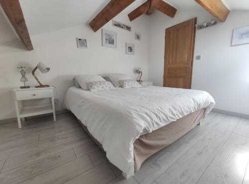 弗维沃L'Ansolane的白色卧室设有一张大床和木地板