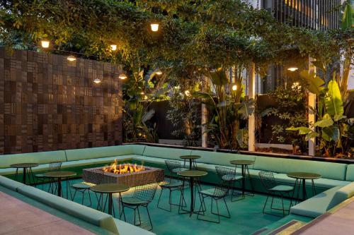 洛杉矶The Delphi Hotel的一个带桌椅的酒吧和一个火坑