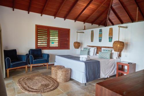 圣米格尔-杜戈斯托苏Kauli Seadi Beach Hotel的一间卧室配有一张床、两把椅子和一张桌子