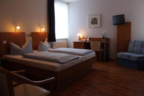 伦茨堡伦茨堡酒店的配有一张床和一把椅子的酒店客房