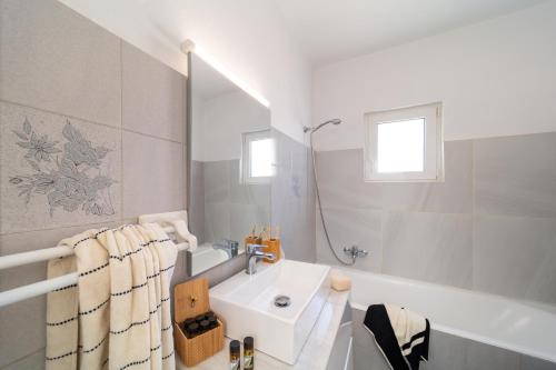 罗德镇Emelia Cozy Apartment的白色的浴室设有水槽和浴缸。