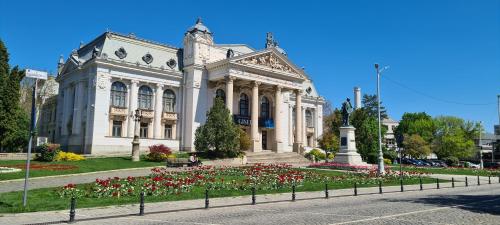 雅西Genesis - Iasi City Center的一座白色的大建筑,前面有鲜花