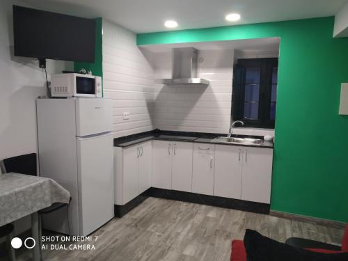 里瓦德奥O RECUNCHO DE BERE的厨房配有白色橱柜和绿色墙壁