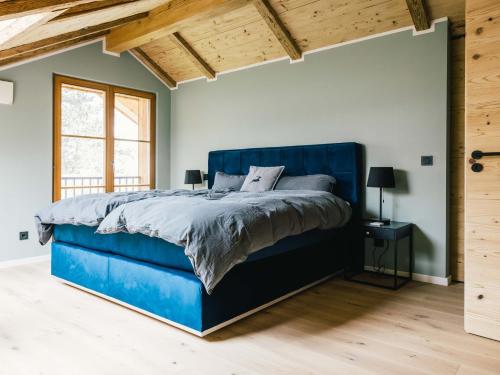 特劳恩施泰因Wolke 9A的卧室内的一张蓝色的床,拥有木制天花板