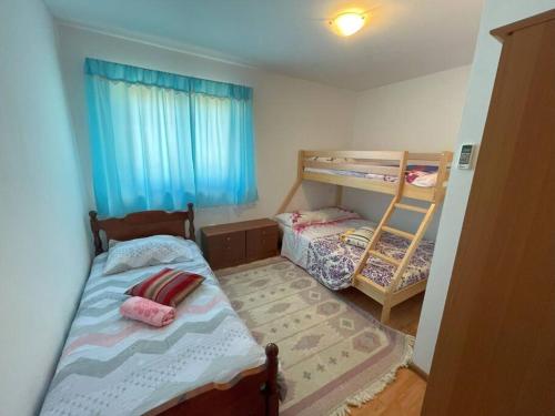 罗波里卡Villa Rosa Apartman的小房间设有两张双层床和窗户