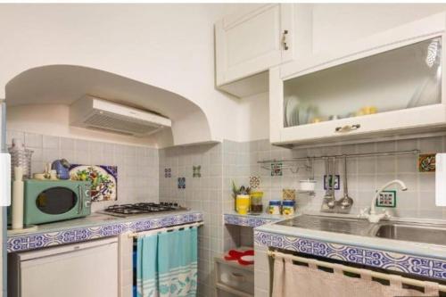 加利波利Casa Centro storico Gallipoli的厨房配有水槽和微波炉