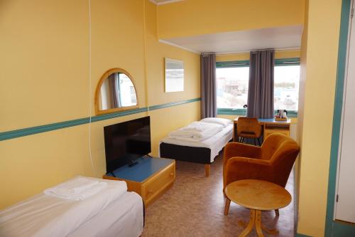 拉克塞尔夫Verdde Hotel Lakselv的酒店客房,配有两张床和椅子