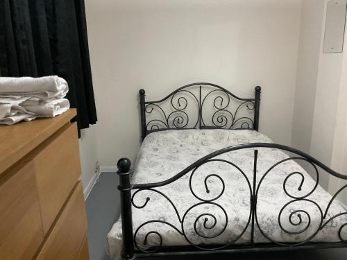 帕尔默斯格林Comfy Double Room In Our Shared House的配有梳妆台的房间的一张黑色床