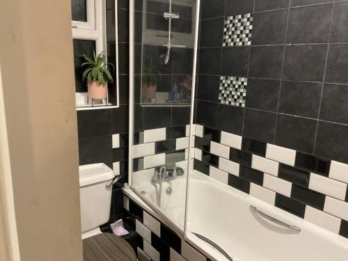 帕尔默斯格林Comfy Double Room In Our Shared House的浴室设有黑色和白色的瓷砖墙