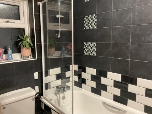 帕尔默斯格林Comfy Double Room In Our Shared House的黑白浴室设有淋浴和浴缸。