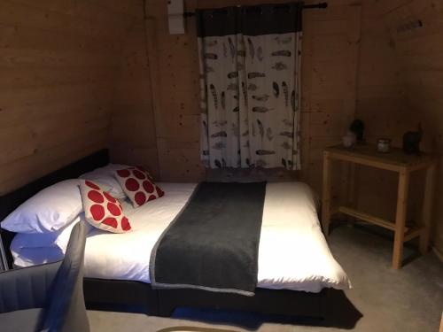 博德明Camping Pods at Colliford Tavern的木制客房内的一间卧室,配有一张床