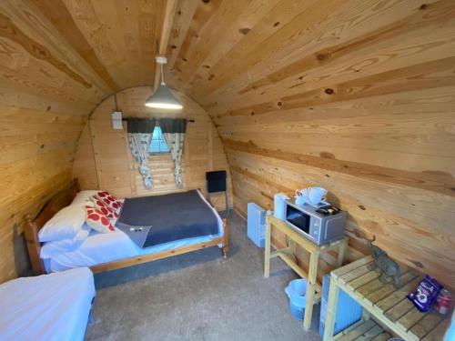 博德明Camping Pods at Colliford Tavern的小木屋内一间卧室配有一张床和一台电视