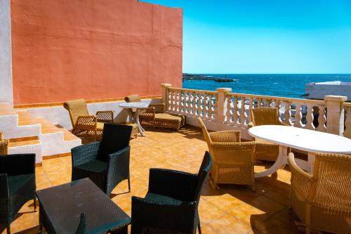 La MaretaHostel Blue Lagoon的一个带桌椅的庭院和大海