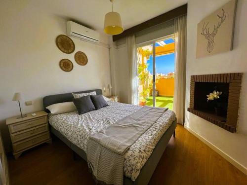 卡博皮诺Apartment close to Marbella的一间卧室设有一张床和一个大窗户