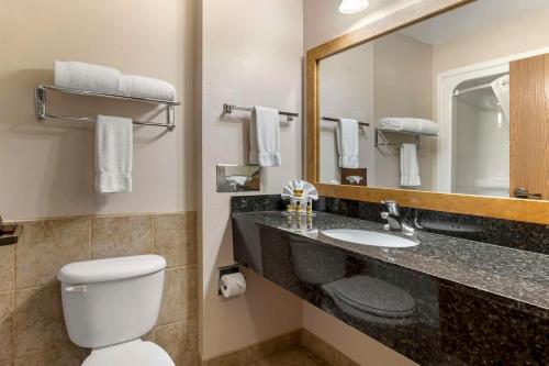 道奇城乡村贝斯特韦斯特PLUS套房酒店的一间带卫生间、水槽和镜子的浴室