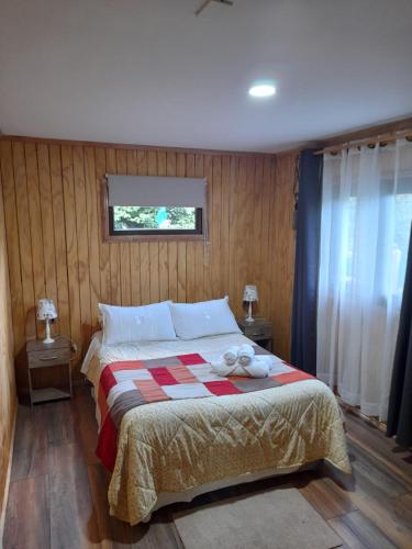 科伊艾科Borde Rio Coyhaique Cabaña y Tinaja的一间卧室配有一张带 ⁇ 子毯子的床