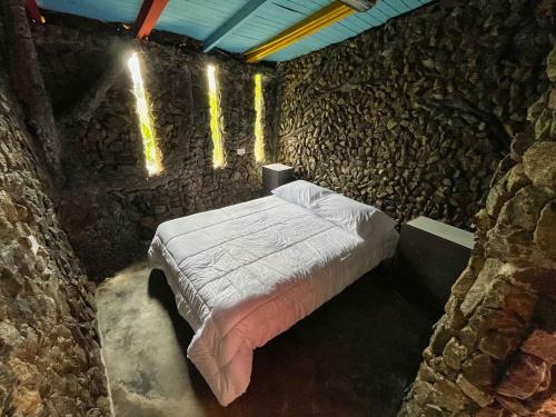 麦德林Cabaña Parque Arvi vista panorámica的卧室配有一张石墙床