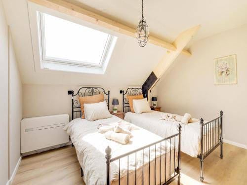 布雷Luxurious 5-star house in Limburg with jacuzzi, a paradise for families的阁楼卧室设有两张床,配有窗户