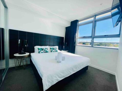 悉尼Sydney Executive Apartment 3beds2baths parking Chatswood的卧室设有一张白色大床和一扇窗户。