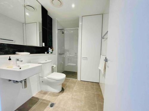 悉尼Sydney Executive Apartment 3beds2baths parking Chatswood的白色的浴室设有卫生间和水槽。