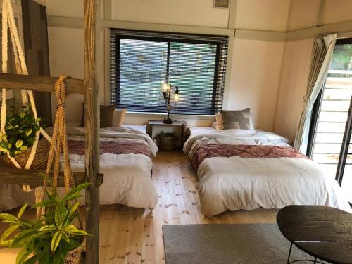 长野１日1組様限定　「ほしな屋」的一间卧室设有两张床和窗户。