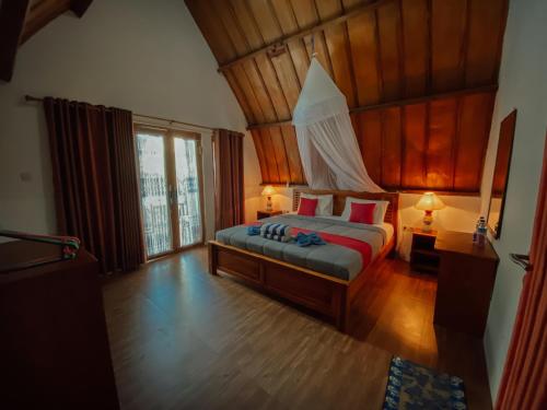 吉利特拉旺安Uki village的一间卧室设有一张带木制天花板的大床