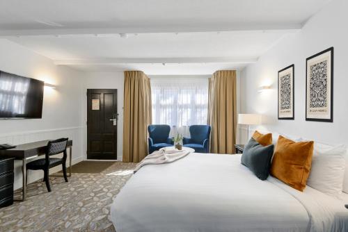 基督城Scenic Hotel Cotswold的酒店客房设有一张大床和一张书桌。