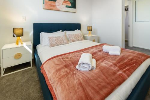 基督城The City's Best Kept Secret 2 bed 2 bath的一间卧室配有一张大床和两条毛巾