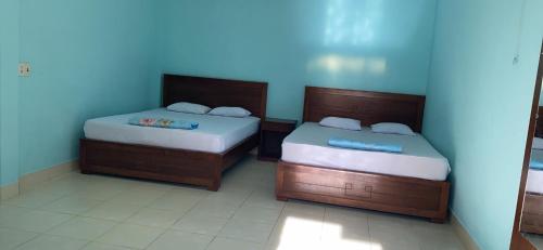 美奈郎差宾馆 的两张睡床彼此相邻,位于一个房间里