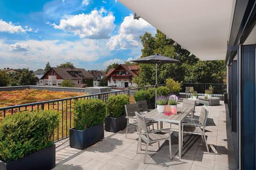 慕尼黑慕尼黑MLOFT公寓式酒店的庭院配有桌椅和遮阳伞。