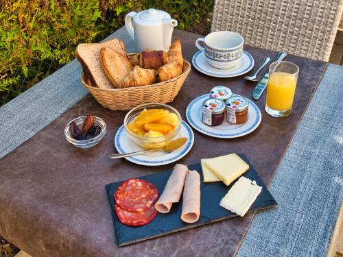 莱塞齐耶德泰阿克Hôtel des Roches - Climatisation的一张带面包和一篮子食物的野餐桌