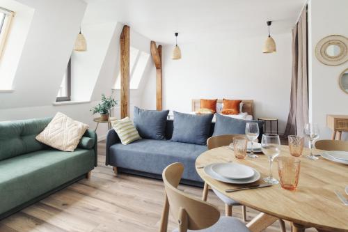 托伦Manpro Apartments Toruń的客厅配有蓝色的沙发和桌子