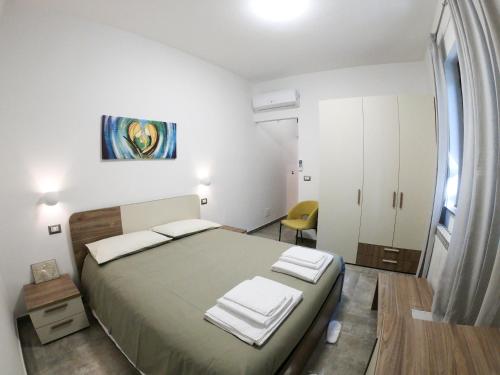 UcriaB&B Tenuta Piano Campo的一间卧室配有一张大床和一张黄色椅子