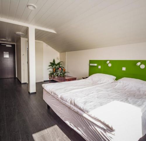 ArtjärviBed and Breakfast Artjärvi的一间卧室配有一张大床和绿色床头板
