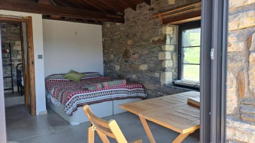 伊兹密尔Peaceful Stone House with Nature View in Karaburun的一间卧室配有一张床和一张木桌