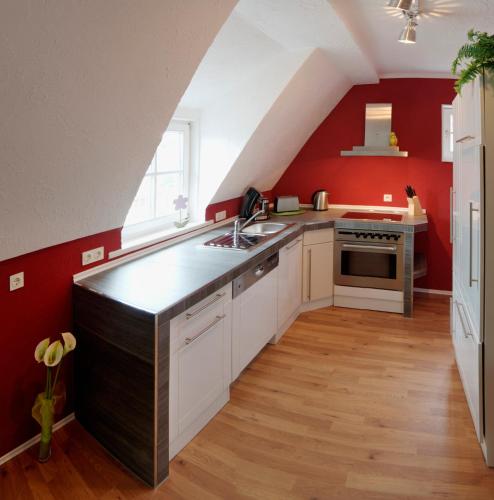 苏尔Appartement Stadtpartie的阁楼厨房设有红色的墙壁和厨房岛